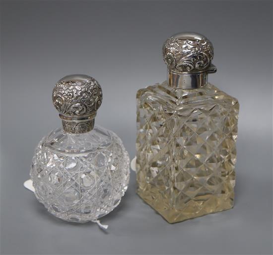 A silver-mounted cut glass toilet bottle and another similar bottle.